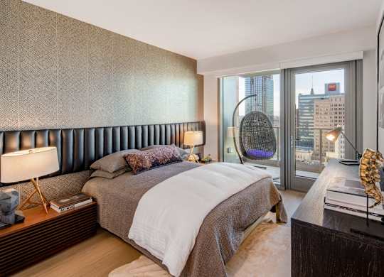 A bedroom with a large bed and a view of the city.