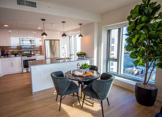 A modern kitchen with a dining table set for four.