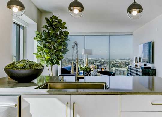 A modern kitchen with a large window overlooking the city.