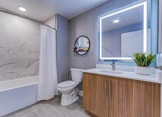 A bathroom with a white tub, toilet, and sink.