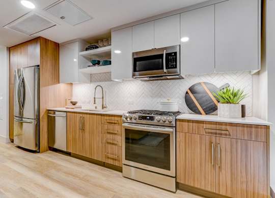 A modern kitchen with wooden cabinets and stainless steel appliances.