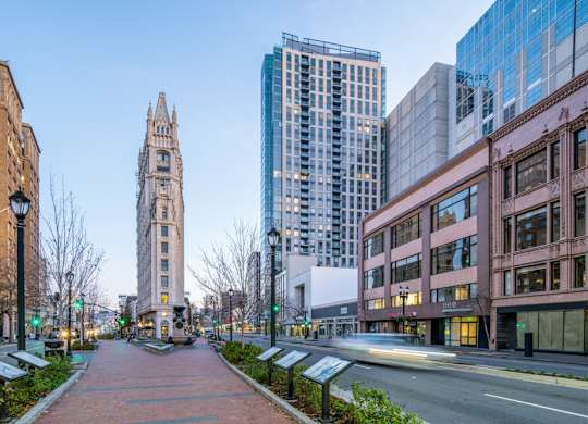 A city street with a tall building in the background.