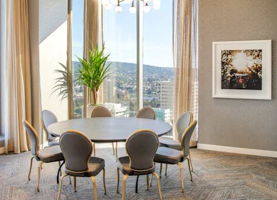 A dining room with a table and chairs and a view of the city.
