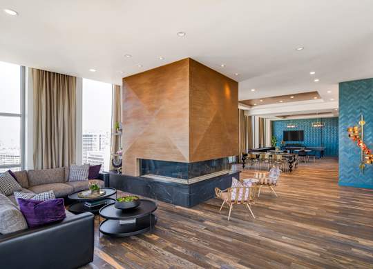 A modern living room with a wooden floor and a large wooden wall unit.