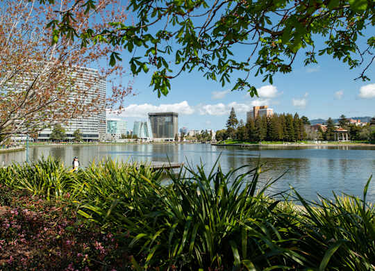 A person is standing on a dock by a lake.
