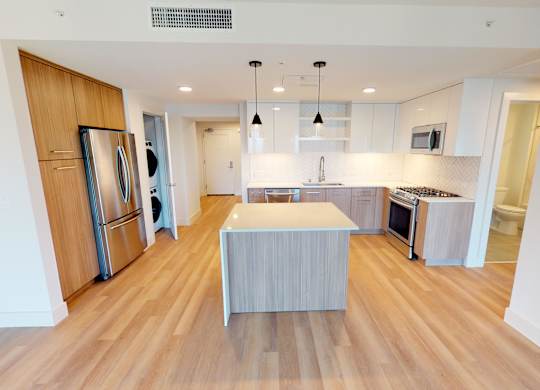 A kitchen with a wooden floor and a white ceiling.