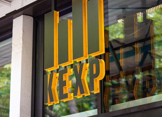 Window sign with gold lettering and vertical bars at Axis Seattle Apartments, Seattle, WA