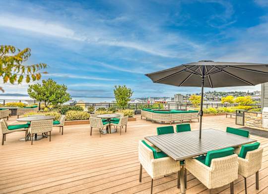 Rooftop deck with dining tables and city views at Axis Seattle Apartments, Seattle, 98109