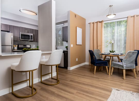 a living room and kitchen with a dining room table and chairs