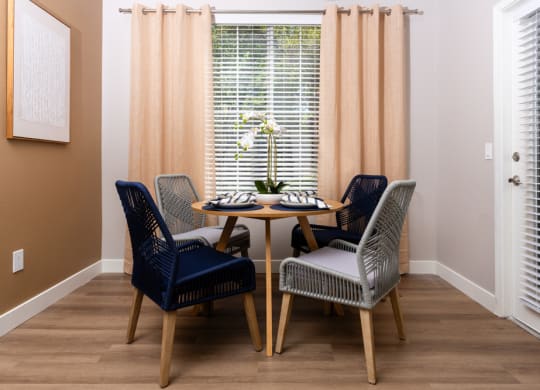a dining room with a table and chairs and a window
