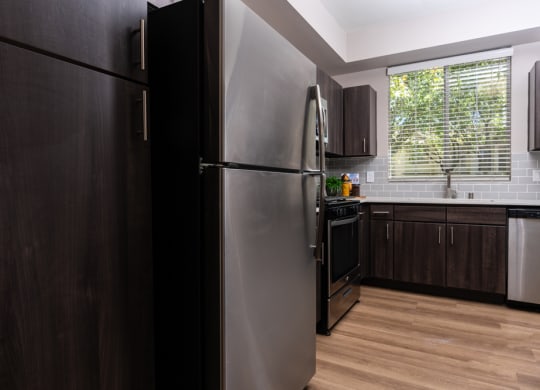 a kitchen with a stainless steel refrigerator and a window