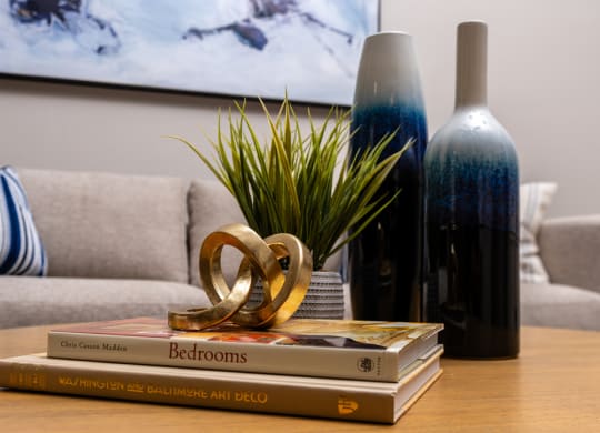 a stack of books sitting on a table with a bottle of wine