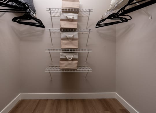 a closet with a rack with bags and shoes in it