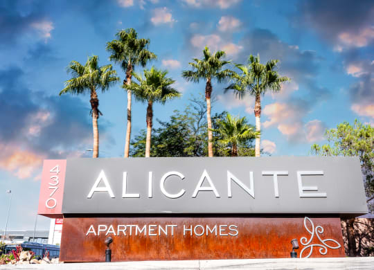 a sign for alicante apartment homes with palm trees