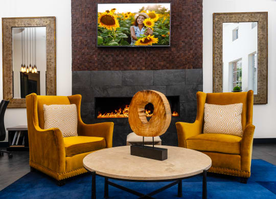 a living room with yellow chairs and a fireplace     and a table
