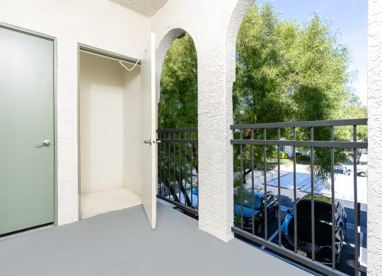 a balcony with a door to a parking lot