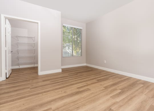 an empty room with wood flooring and a closet