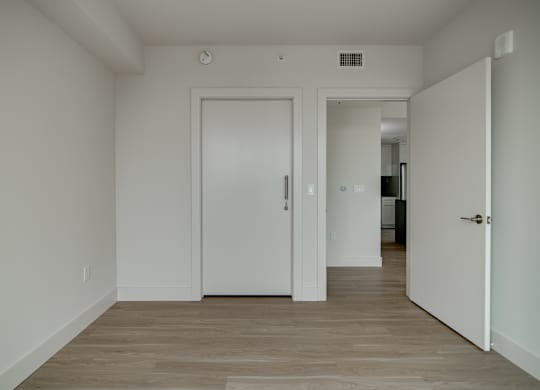 A white door is in a room with wood flooring.
