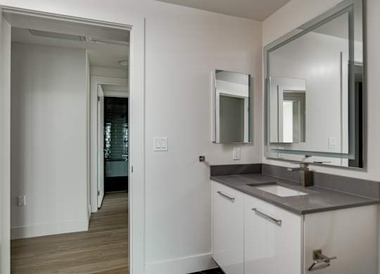 A bathroom with a sink, mirror and cabinet.