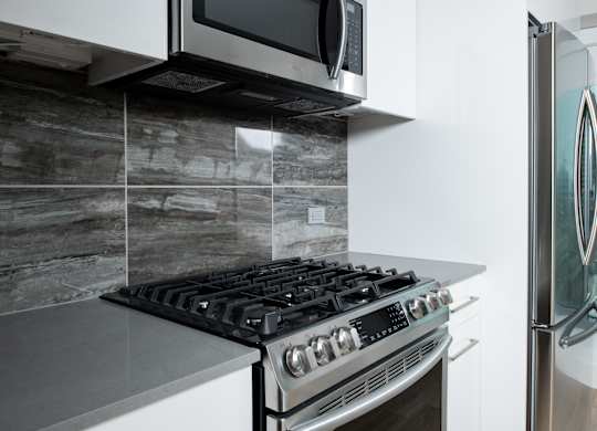 A modern kitchen with a stove and a microwave above it.