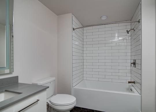A white bathroom with a toilet, sink, and bathtub.