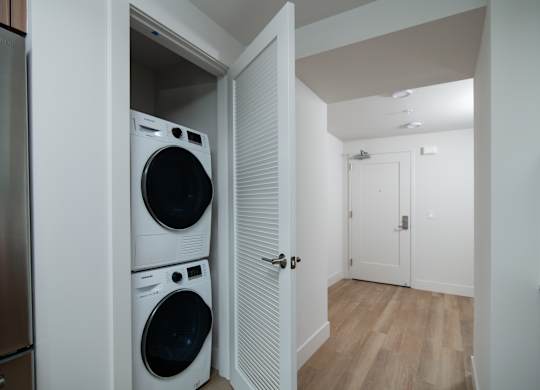 A laundry room with a washer and dryer stacked on top of each other.