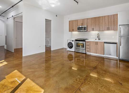 A kitchen with brown floors and white walls.