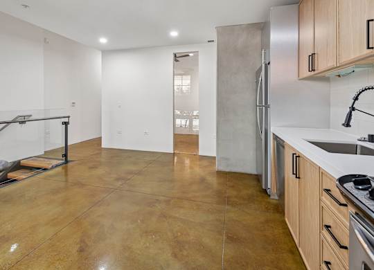 A kitchen with a refrigerator, sink, and stove top oven.