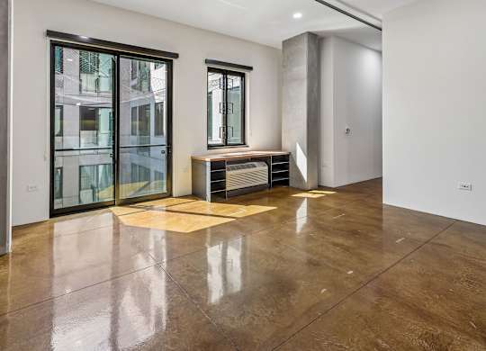 A room with a brown floor and a window.