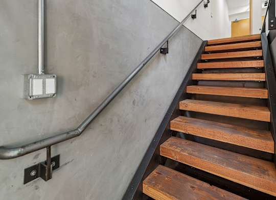 A staircase with wooden steps and a metal handrail.