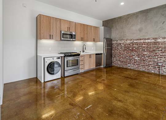 A kitchen with a refrigerator, oven, and microwave.