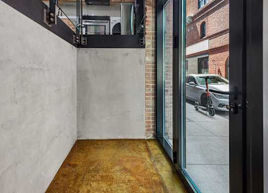 A white wall with a black door and a window.