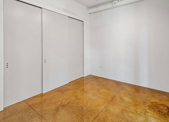 A room with a brown floor and white walls.