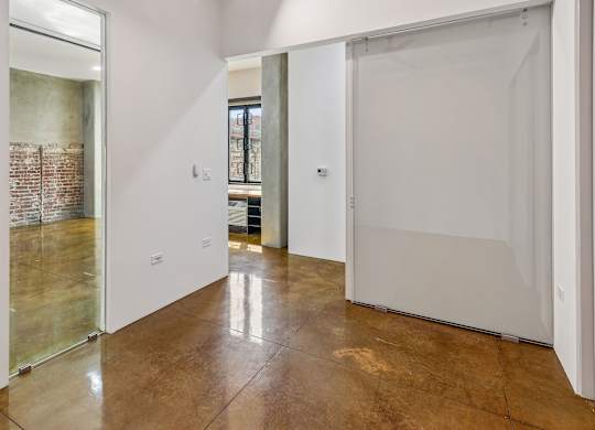 A room with a brown floor and white walls.