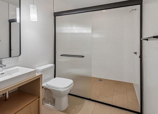 A white toilet sits in a bathroom next to a sink.