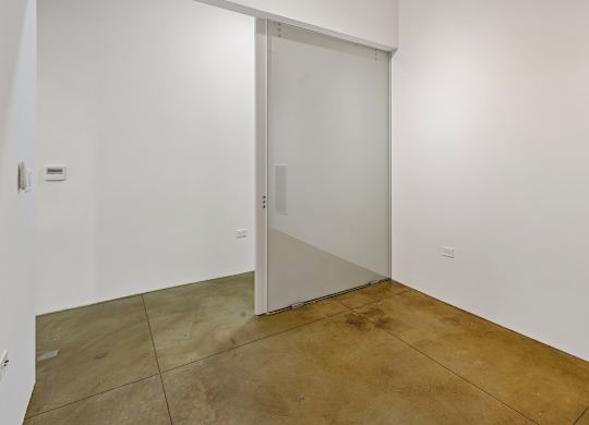 A room with a white wall and a glass door.