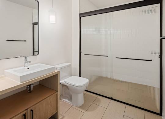 A white toilet sits in a bathroom next to a sink.