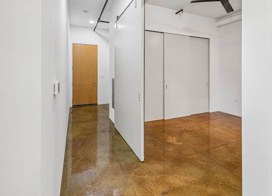 A room with a brown floor and white walls.
