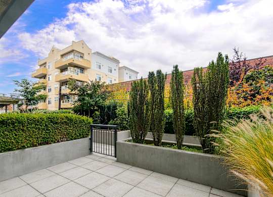 Private patio with concrete planters and landscaping at Axis Seattle Apartments, Seattle, Washington