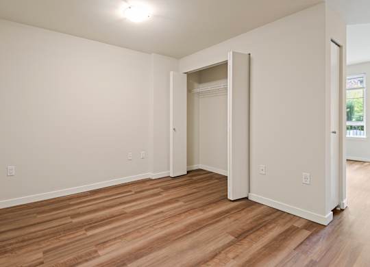 Empty bedroom with wood flooring and closet at Axis Seattle Apartments, Washington