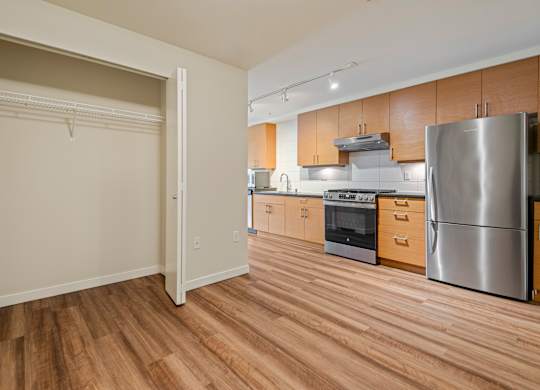 Kitchen with stainless steel appliances and wood floors at Axis Seattle Apartments, Washington, 98109