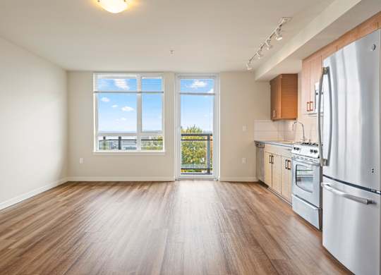 Open floor plan with kitchen and balcony access at Axis Seattle Apartments, Seattle, Washington