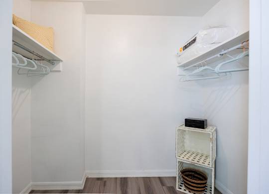 A small white closet with a shelf and a hanging rod.