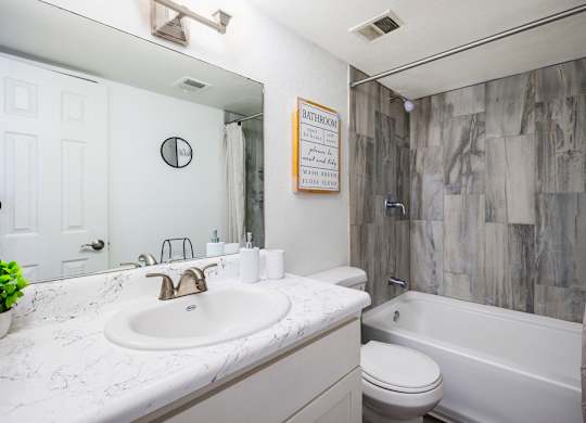 A bathroom with a white sink and a white toilet.