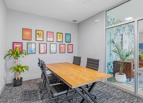 A conference room with a long table, chairs, and framed pictures on the wall.