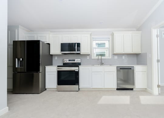 A kitchen with white cabinets and appliances.