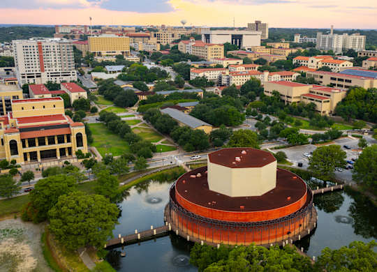 A large building with a red and white dome sits in the middle of a body of water.