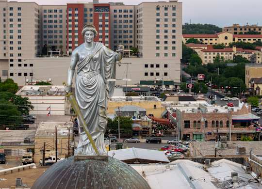 A statue of a woman at The Courthouses of Hays County monument