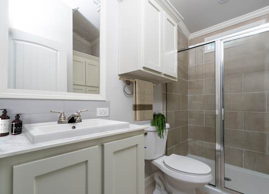 A bathroom with a toilet, sink, and shower.
