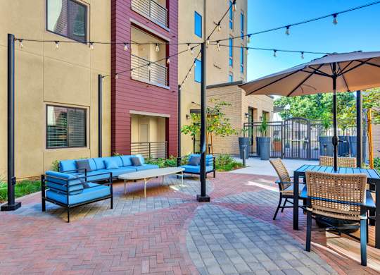 A patio with a blue sofa and chairs.